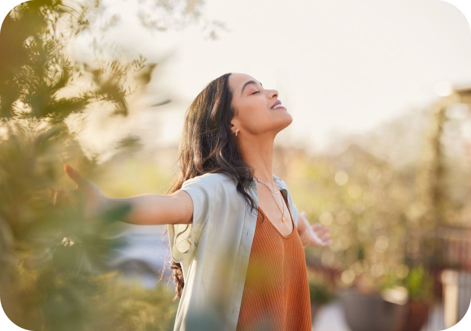 Woman with her arms out, enjoying the sunshine.