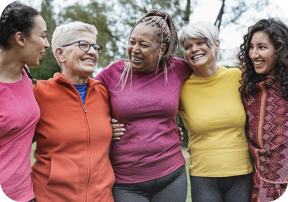 Group of women in different stages of their lives, hugging.