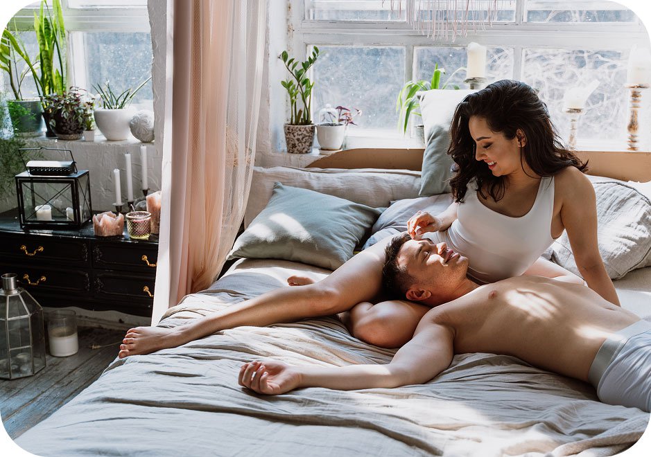 Couple laying in bed together feeling sexy.